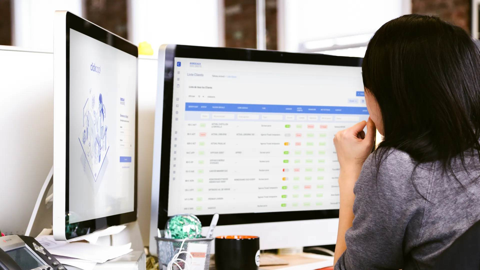 Femme assise au bureau devant ses écrans clickapp!